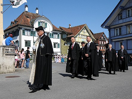 Behoerdenmitglieder gekleidet in schwarzen Maenteln.JPG